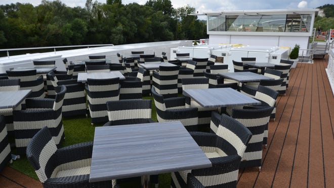 The front of the deck-top area of the Scenic Gem features tables and chairs.