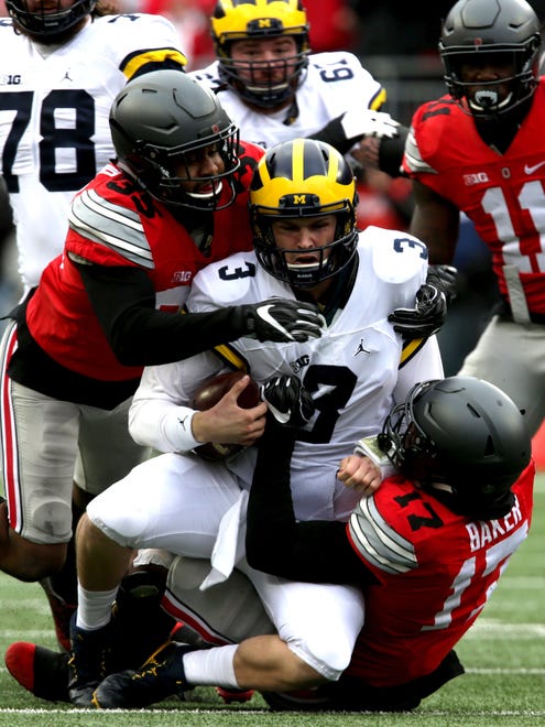 Michigan quarterback Wilton Speight is sacked in the first quarter by Ohio State's Jerome Baker (17) and Chris Worley at Ohio Stadium on Saturday, Nov. 26, 2016.
