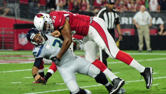 Arizona Cardinals defensive end Calais Campbell (93) tackles Seattle Seahawks quarterback Russell Wilson (3) during the first half at University of Phoenix Stadium.