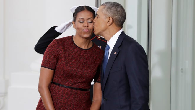 Obama kisses the first lady as they await for the arrival of President-elect Donald Trump and his wife, Melania, at the White House on Jan. 20, 2017.