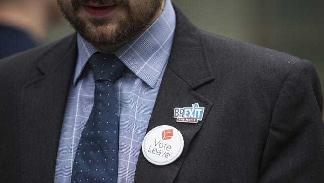 A 'Vote Leave' campaigner displays campaign buttons on his suit on June 22, 2016, in London.