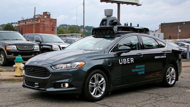 A self driving Uber car drives down River Road on Pittsburgh's Northside
