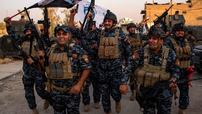 Members of the Iraqi federal police forces celebrate in the Old City of Mosul on July 10, 2017 after the government's announcement of the "liberation" of the embattled city from Islamic State group fighters.