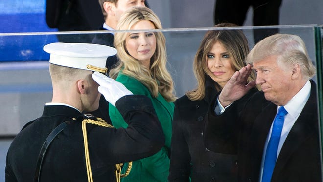 President-elect Donald Trump salutes as his wife Melania and daughter Ivanka Trump, center, look on during an inauguration concert at the Lincoln Memorial, in Washington, DC, on Thursday.