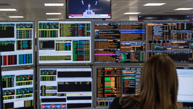 A television screen displays an image of France's President-elect Emmanuel Macron, as traders works on the trading floor of ETX Capital in London on May 8, 2017, following the result of France's presidential election.
(AFP PHOTO / CHRIS J RATCLIFFE/AFP/Getty Images)