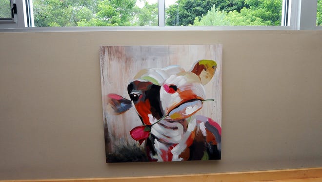 The home is filled large colorful works of art, including this whimsical cow.