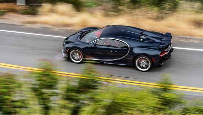 The Bugatti Chiron drives down an open road.