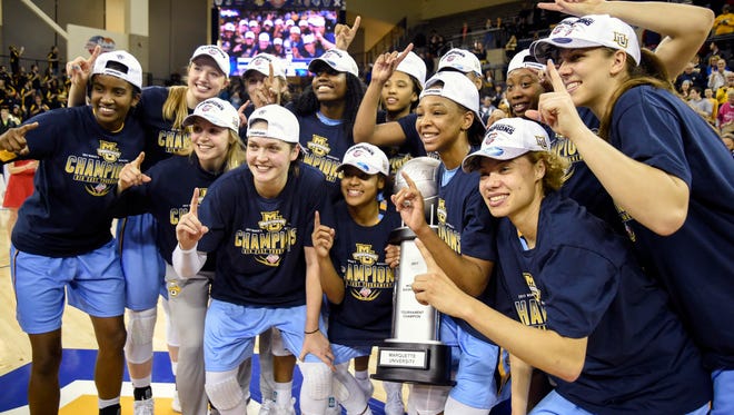 The Marquette women's basketball team poses with its Big East conference tournament trophy.