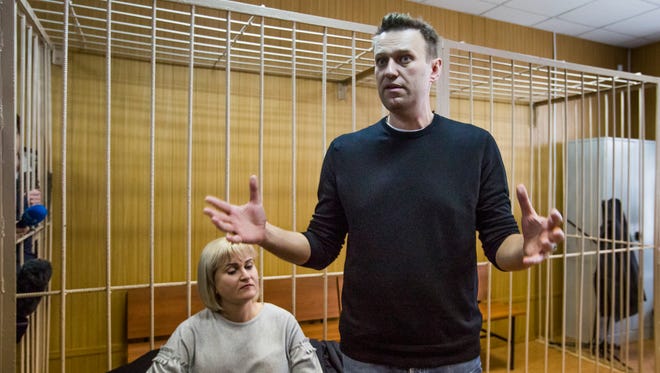 Russian opposition leader Alexei Navalny gestures while speaking, as his lawyer Olga Mikhailova listens, in court in Moscow on March 27, 2017.