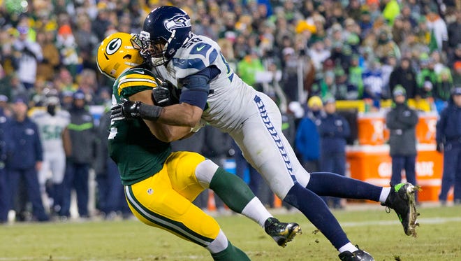 Seahawks linebacker K.J. Wright (50) commits a penalty while tackling Packers tight end Richard Rodgers (82) during the third quarter.