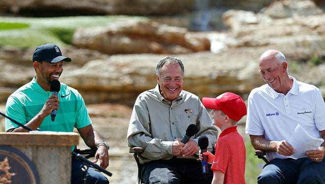 Professional golfer Tiger Woods (left) and Bass Pro Shops founder, CEO Johnny Morris (middle) and fellow golfer Tom Lehman listen to Hudson, Morris' great nephew, ask a  question during a press event announcing a new golf course designed by Tiger Woods with the support of Johnny Morris in Hollister, Mo. on April 18, 2017.