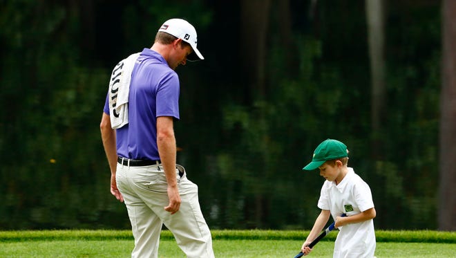 Webb Simpson watches his son putt on the ninth green during the Par 3 Contest.