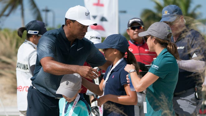 Tiger Woods hugs son Charlie Woods and daughter Sam Woods as Erica Herman looks on before the third round of the Hero World Challenge golf tournament at Albany.
