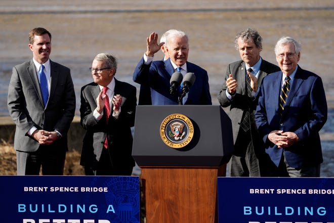 President Joe Biden is joined on stage by (left to right) Andy Bershear, Mike DeWine, Rob Portman, Sherrod Brown and Mitch McConnell as he finishes his speech during an event to give remarks on the bipartisan infrastructure law which will fund major changes to the Brent Spence Bridge and surrounding infrastructure at a lot on the banks of the Ohio River in Covington, Ky., on Wednesday, Jan. 4, 2023.