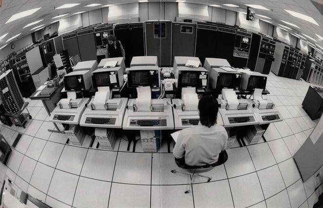 5000 Arlington Centre Blvd. in Upper Arlington , Ohio -- This fisheye view of CompuServe Inc.'s computer room shows mainframes and control terminals. Rear Tommy Thomas - Supervisor, Foreground James Holden, computer operator. Photo by Tim Revell. March 15, 1984.