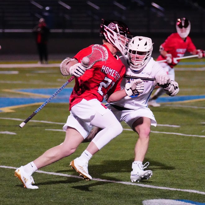 Homestead's Jonah Stanmer (27) battles to get past Mukwonago's Mason Mohr (16) during the boys lacrosse match at Mukwonago on Tuesday, March 19, 2024.