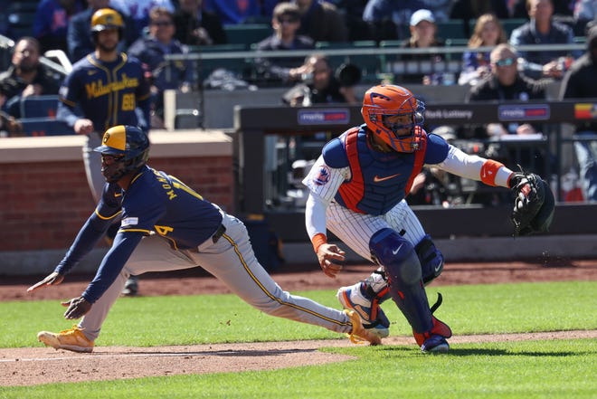 Brewers third baseman Andruw Monasterio scores behind Mets catcher Francisco Alvarez during the fifth inning.