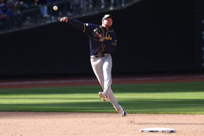 Brewers second baseman Brice Turang throws the ball to first base for an out during the ninth inning.