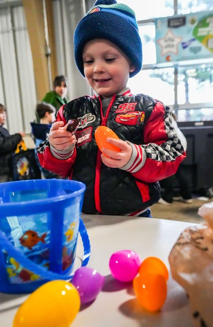 Three-year-old Brooks Fry of Oconomowoc opens a candy-filled egg during the annual Okauchee Lions Easter Egg Hunt at Lions Park on Saturday, March 30, 2024. The free family event is hosted by the Okauchee Lions Club.