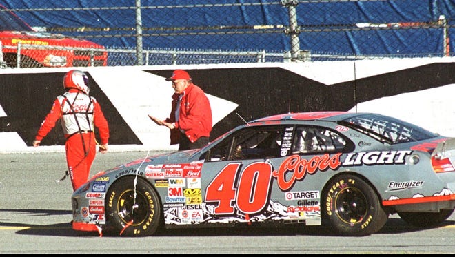 Two-time Daytona 500 champion Sterling Marlin gets a reprimand from a track official  after he tried to pull a bent piece of sheet metal away from his tire during a red-flag stop in the 2002 race. Marlin's gaffe will forever be part of NASCAR's lore, with some saying his illegal attempt to fix his car under the red flag cost him a victory.