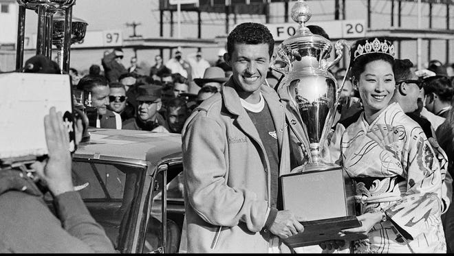 Richard Petty poses with the championship trophy after earning the first of seven Daytona 500 wins in 1964.