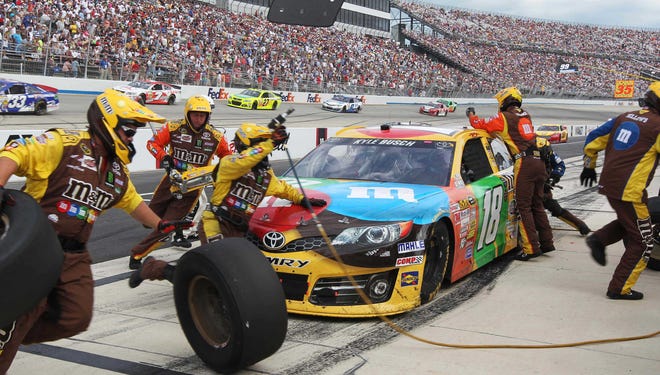 Jun 2, 2013; Dover, DE, USA; NASCAR Sprint Cup Series driver Kyle Busch (18) makes a pit stop during the FedEx 400 Benefiting Autism Speaks at Dover International Speedway. Mandatory Credit: Matthew O'Haren-USA TODAY Sports ORG XMIT: USATSI-128798 ORIG FILE ID:  20130602_pjc_bm2_087.JPG