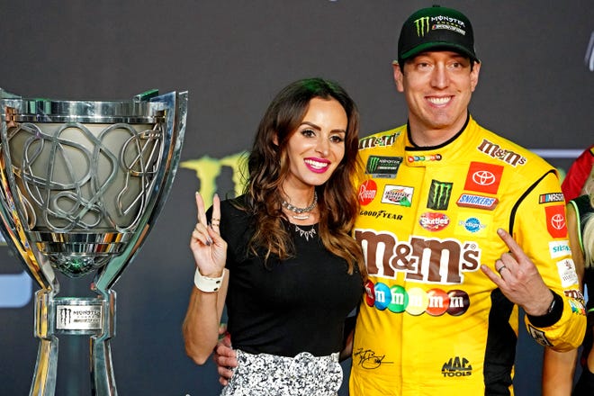 Kyle Busch and his wife Samantha pose with the championship trophy after winning his second NASCAR Cup Series title on Nov. 17, 2019 at Homestead-Miami Speedway.