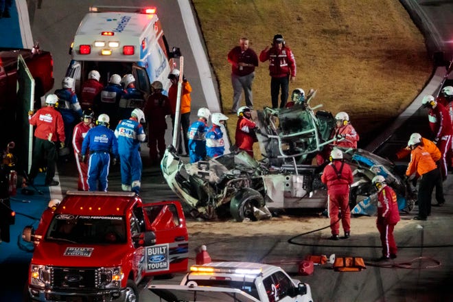 Safety crews rush to move driver Ryan Newman to an ambulance after his car crashed, flipped, landed upside-down and then skidded down in a shower of sparks and flames on the final lap of the 2020 Daytona 500.
