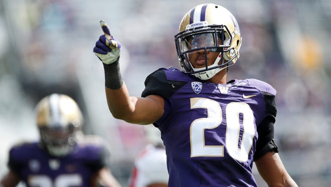 Washington Huskies defensive back Kevin King points to the stands after making a tackle for a loss against Rutgers.