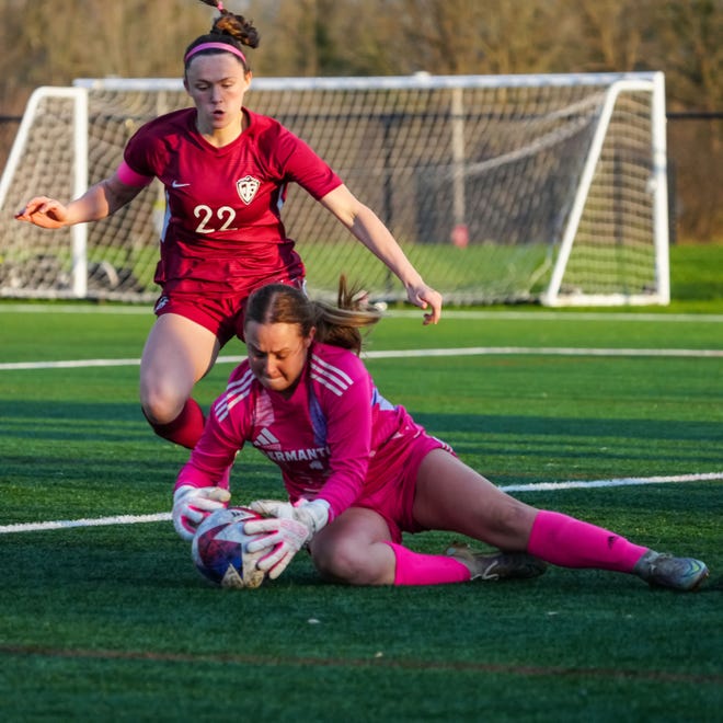 Germantown keeper Jolie Angers (1) dives on the ball with Menomonee Falls' Clare Shea (22) closing fast during the match at Menomonee Falls, Tuesday, April 23, 2024.